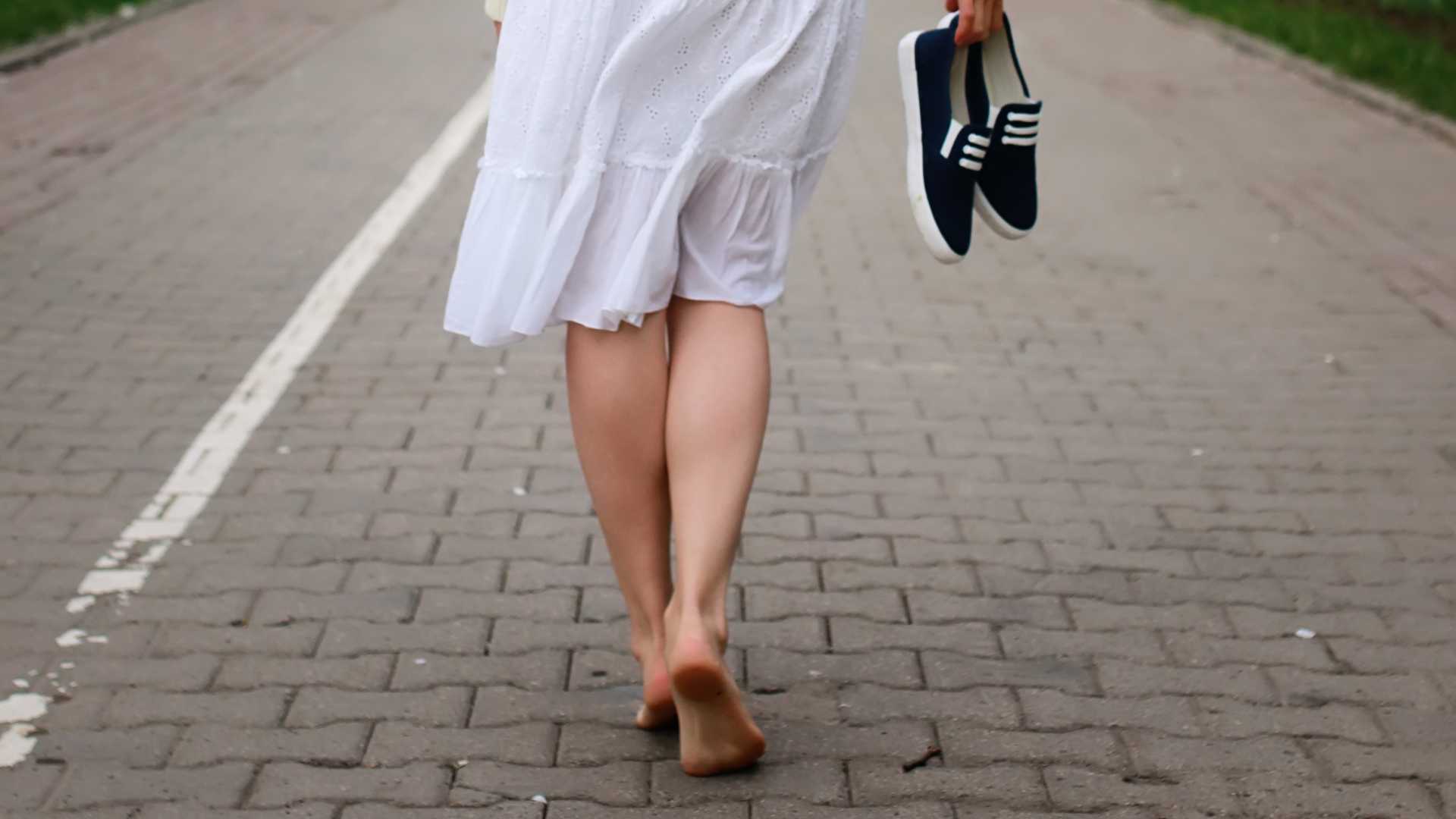 woman walking barefoot in the street